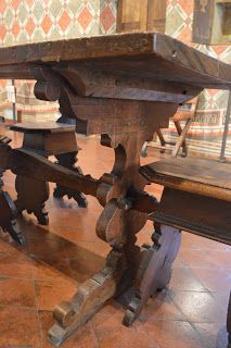 an old wooden table with two benches underneath it