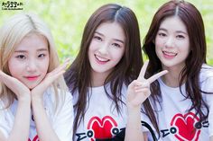 three young women posing for the camera with their fingers in the shape of two hearts