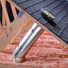 a metal pipe sticking out of the side of a roof that is covered in insulation