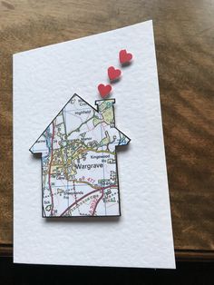 a piece of paper with some red hearts on top of it and a map in the shape of a house