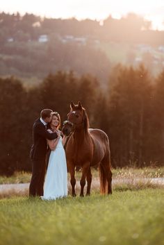 a bride and groom standing next to a horse