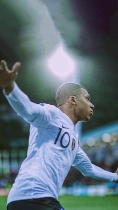 a soccer player in action on the field with his arms out to catch the ball