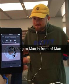 a man wearing headphones while holding an mp3 player in front of him with the words listening to mac in front of him