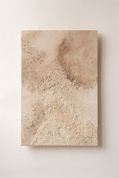 a piece of art that looks like dirt on the ground with white walls behind it