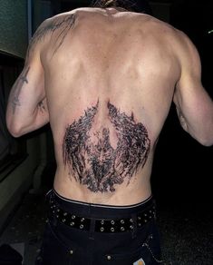 the back of a man with tattoos on his chest