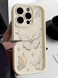 a person holding an iphone case with butterflies on it