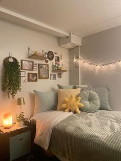 a bed room with a neatly made bed and lots of pictures hanging on the wall