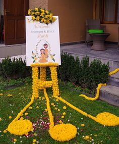 a sign that is made out of flowers in front of a building with stairs leading up to it