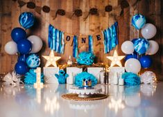 a blue and white birthday party with balloons