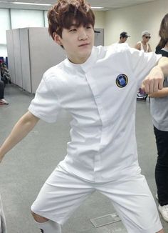 a young man dressed in white poses for a photo