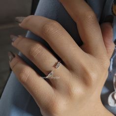 a woman's hand with a diamond ring on her left hand and two diamonds on the middle finger