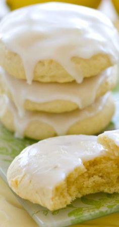 two lemon cookies with icing on a green and yellow plate next to some bananas