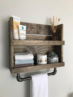 a wooden shelf with two shelves holding towels and other bathroom items on top of it