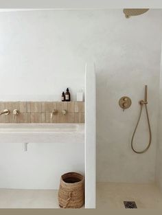 a bathroom with a sink, shower head and toilet paper dispenser in it