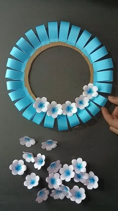 paper flowers are being made into a blue and white flower wreath with the petals cut out