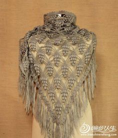 a woman's shawl with crochet work on it