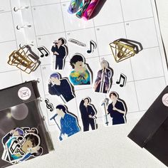 some stickers are laying on top of a calendar with music notes and other items