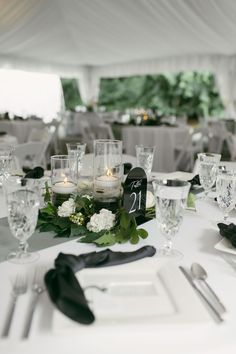 the table is set with candles, flowers and silverware for an elegant wedding reception