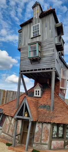 an unusual house built into the side of a wooden structure with windows and doors on top