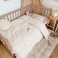 a bed with white sheets and pillows on top of it next to a wooden table