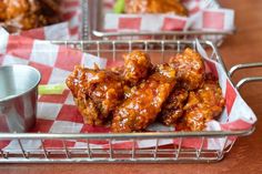 some food is sitting on a red and white checkered table cloth next to a silver cup