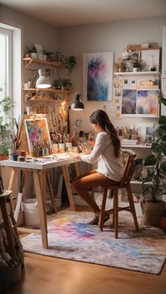 a woman sitting at a desk in front of an easel filled with art supplies