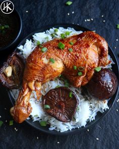 a black plate topped with chicken and rice