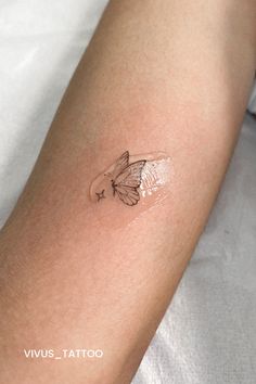 a small tattoo on the arm of a woman's left arm with a butterfly