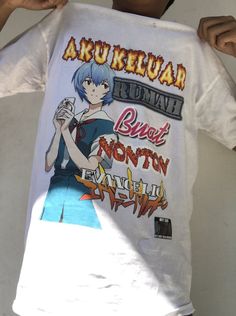 a man holding up a white shirt with anime characters on it's chest and the words aru keluar