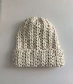 a white knitted hat sitting on top of a table