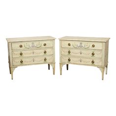 a pair of white dressers sitting next to each other