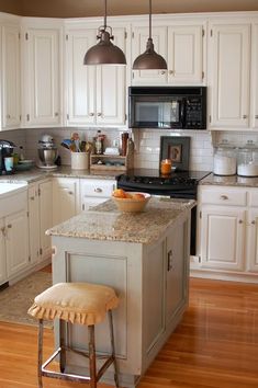 an island in the middle of a kitchen with two stools on top of it