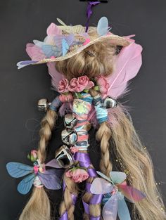 a doll with long blonde hair wearing a hat and flowers on it's head