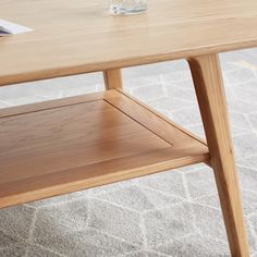 a wooden coffee table with a glass on the top and an open shelf below it