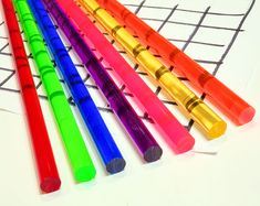 five different colored pens lined up on top of a piece of paper