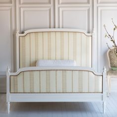 a white bed sitting in the middle of a room