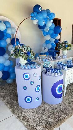 blue and white balloons are on display in front of a table with vases filled with flowers