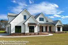 a large white house sitting on top of a lush green field