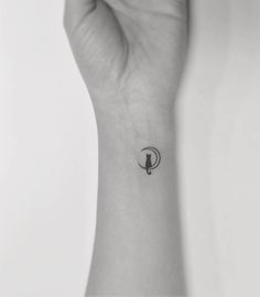 a person's wrist with a small tattoo on it