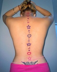 the back of a woman's body with tattoos on her upper and lower back