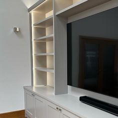 a flat screen tv sitting on top of a white entertainment center