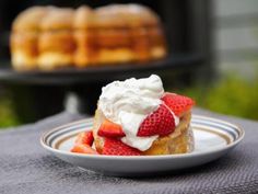 a piece of cake with whipped cream and strawberries on it sitting on a plate