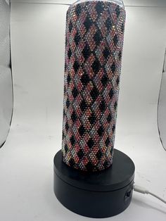 a black and white vase sitting on top of a table next to a wall light