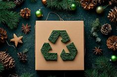 a cardboard box with green recyclables on it surrounded by christmas decorations