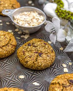 oatmeal cookies on a metal tray next to flowers