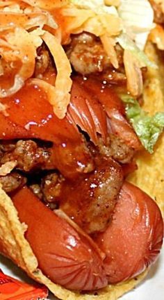 a close up of a hot dog on a plate with corn tortilla chips