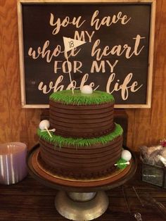 a chocolate cake with green grass on top and a sign that says you have who's heart for my whole life