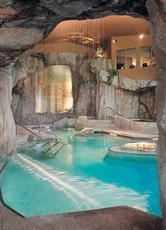 an indoor swimming pool surrounded by large rocks