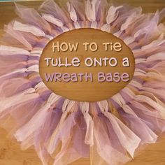 a pink tulle on top of a wooden surface with words written below it that says how to tie tulle onto a wreath base