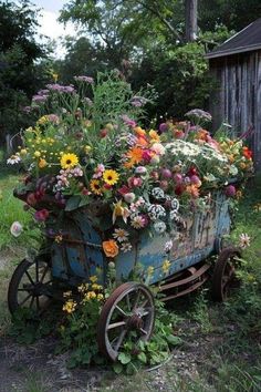 an old blue wagon filled with lots of flowers